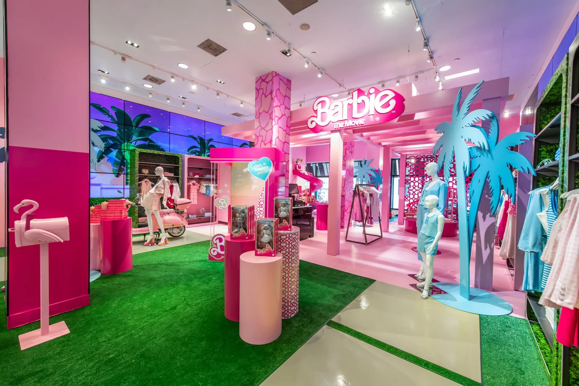Bloomingdale's, capsule Barbie : l'espace tout en rose, palmiers bleus, flamant, gazon vert et mur vidéo de palmiers