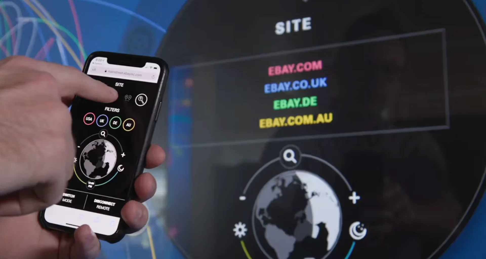 eBay Earth : une main pilote le globe depuis un téléphone, l'écran affiche les filtres par site